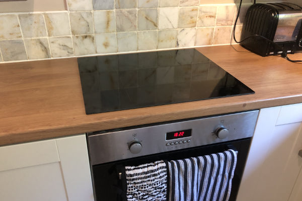 Slick black glass induction hob on a wood effect worktop