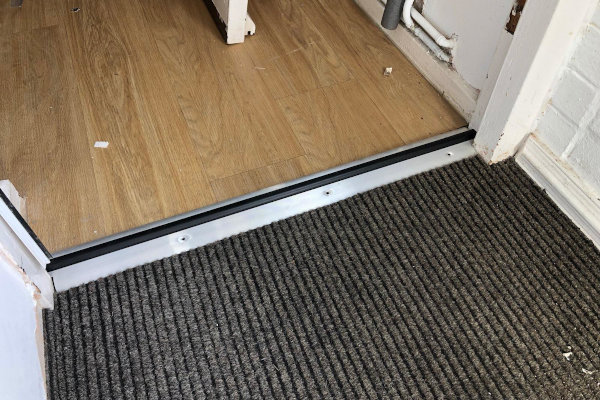 Stormguard threshold in place with the carpet and vinyl neatly meeting it