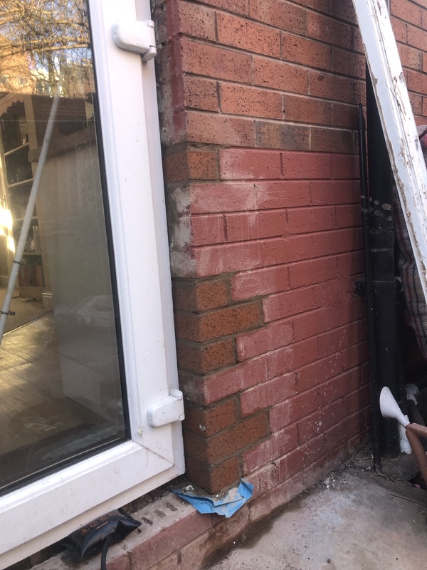 New red Trafford bricks installed into the wall to replace the broken ones.