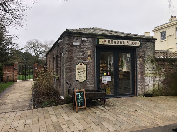 A brick outbuilding with a sign saying 'The Reader shop'